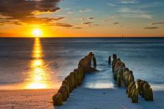Buhnen-Sonnenuntergang-Strand-Nordsee